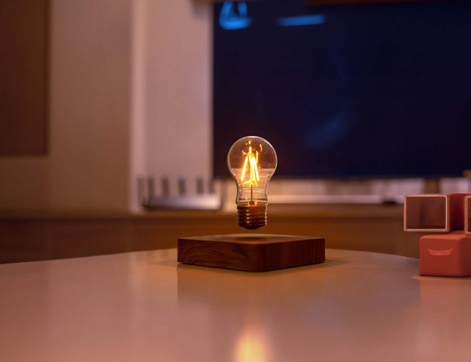Lampada a levitazione magnetica DiProgress LIGHT con base effetto legno su tavolo. Design futuristico e innovativo.